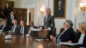 scene of business woman speaking to a room of business men in the white house