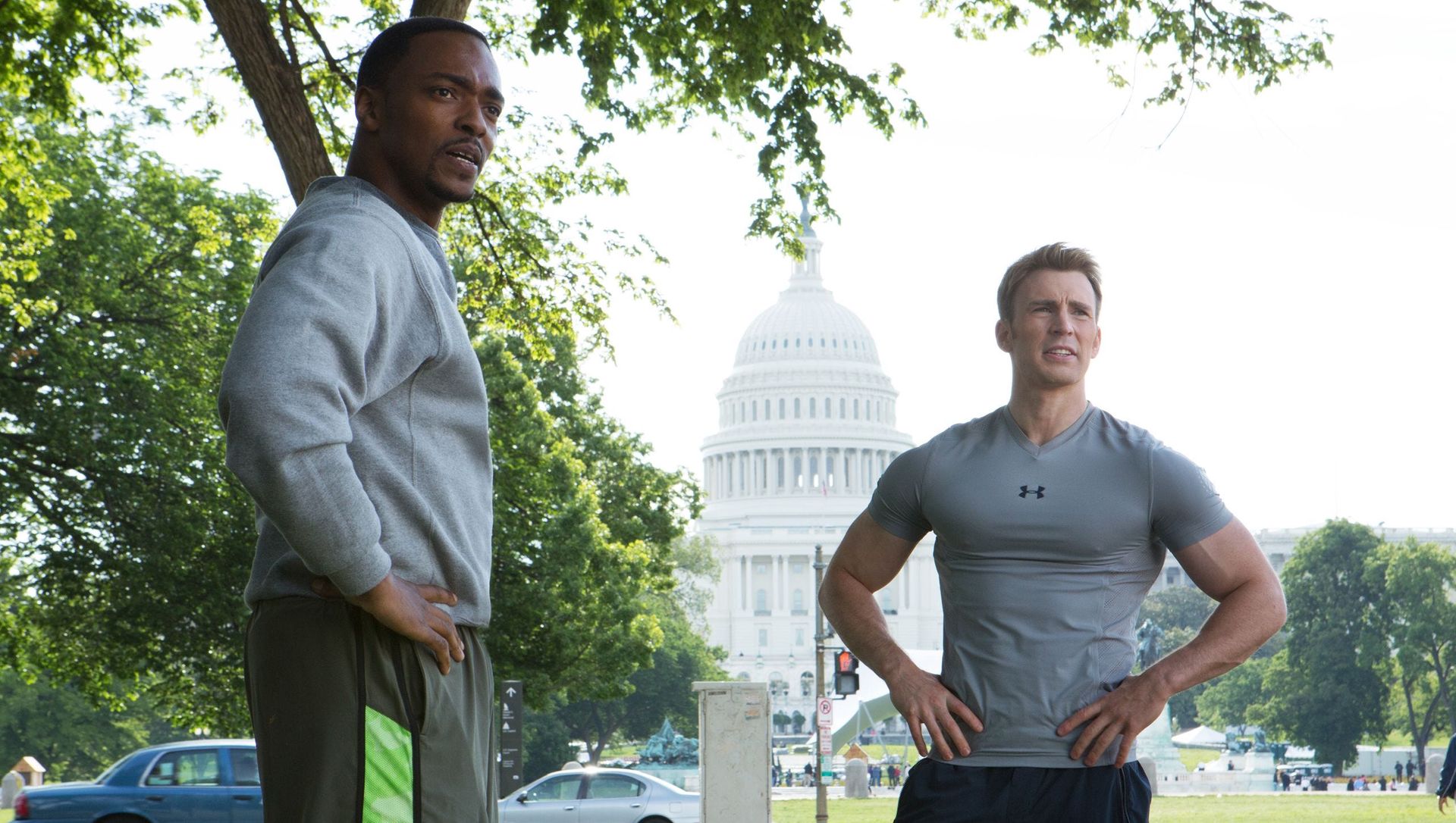 Two men with their hands on their hips talking outside of the White House